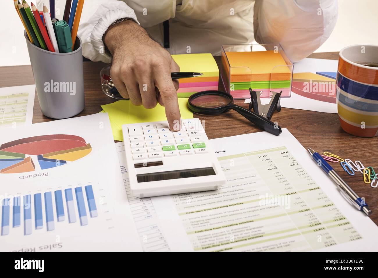 Gros plan d'une main masculine calculant, sur le bureau Banque D'Images