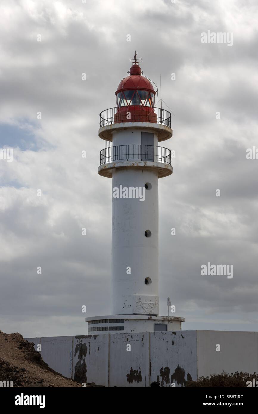 Phare avec façade blanche et dessus rouge, style traditionnel. Ciel bleu avec des nuages intenses. Côte de l'océan Atlantique. Taliarte, Las Palmas, Grande Canarie Banque D'Images