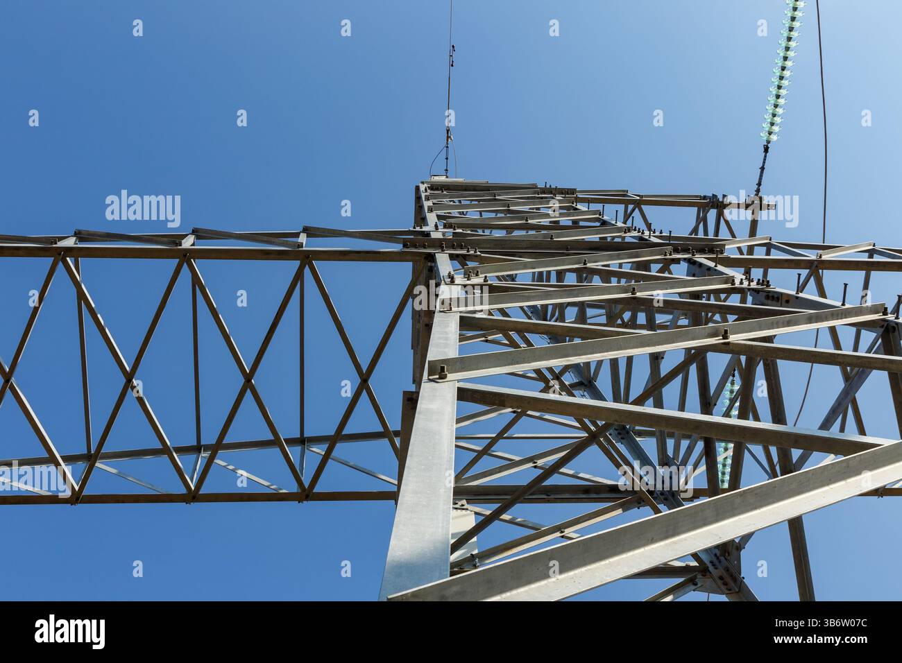 Vue des isolateurs de ligne d'alimentation haute tension face à un ciel bleu clair Banque D'Images