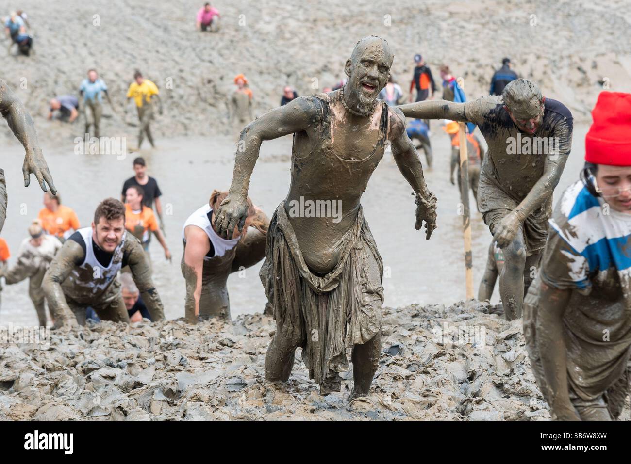 Promenade Park, Maldon, Essex, Royaume-Uni. 4 mai 2025. Un grand nombre de coureurs se sont attaqués au parcours épuisant qui les a emmenés à travers la rivière Chelmer et de retour à marée basse, à travers la boue glissante et accrocheuse. Les concurrents de Maldon Mud Race courent pour la charité, avec beaucoup en robe de fantaisie et tous se couvrent de la boue visqueuse pendant la course, en particulier ceux qui sont plus en arrière une fois que la boue est barattée Banque D'Images