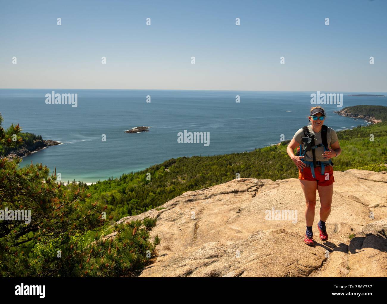 Femme atteint Granite Slab sur la montagne Champlain avec vue sur l'Atlantique Banque D'Images