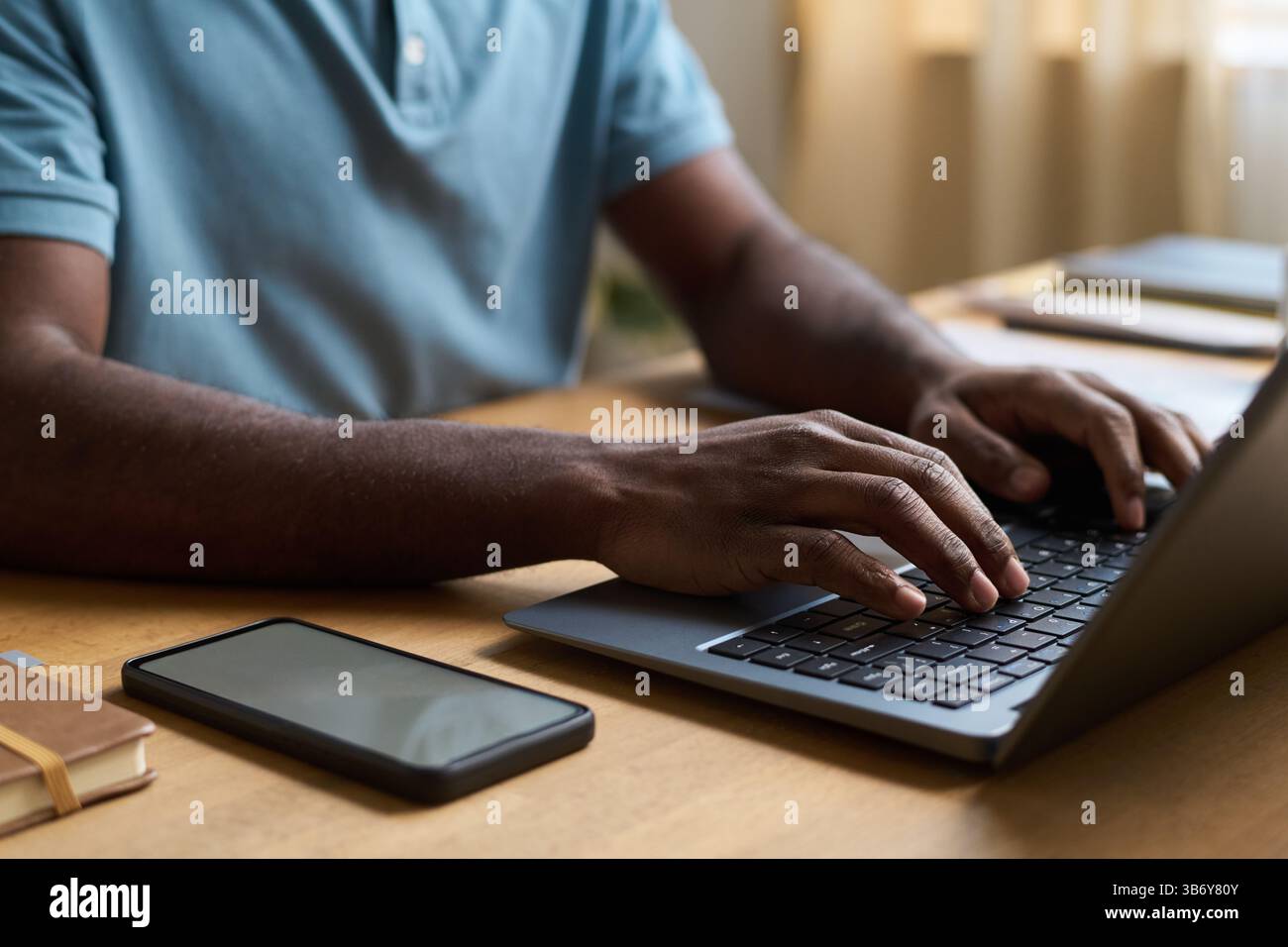 Mains masculines texturant sur l'ordinateur portable Banque D'Images