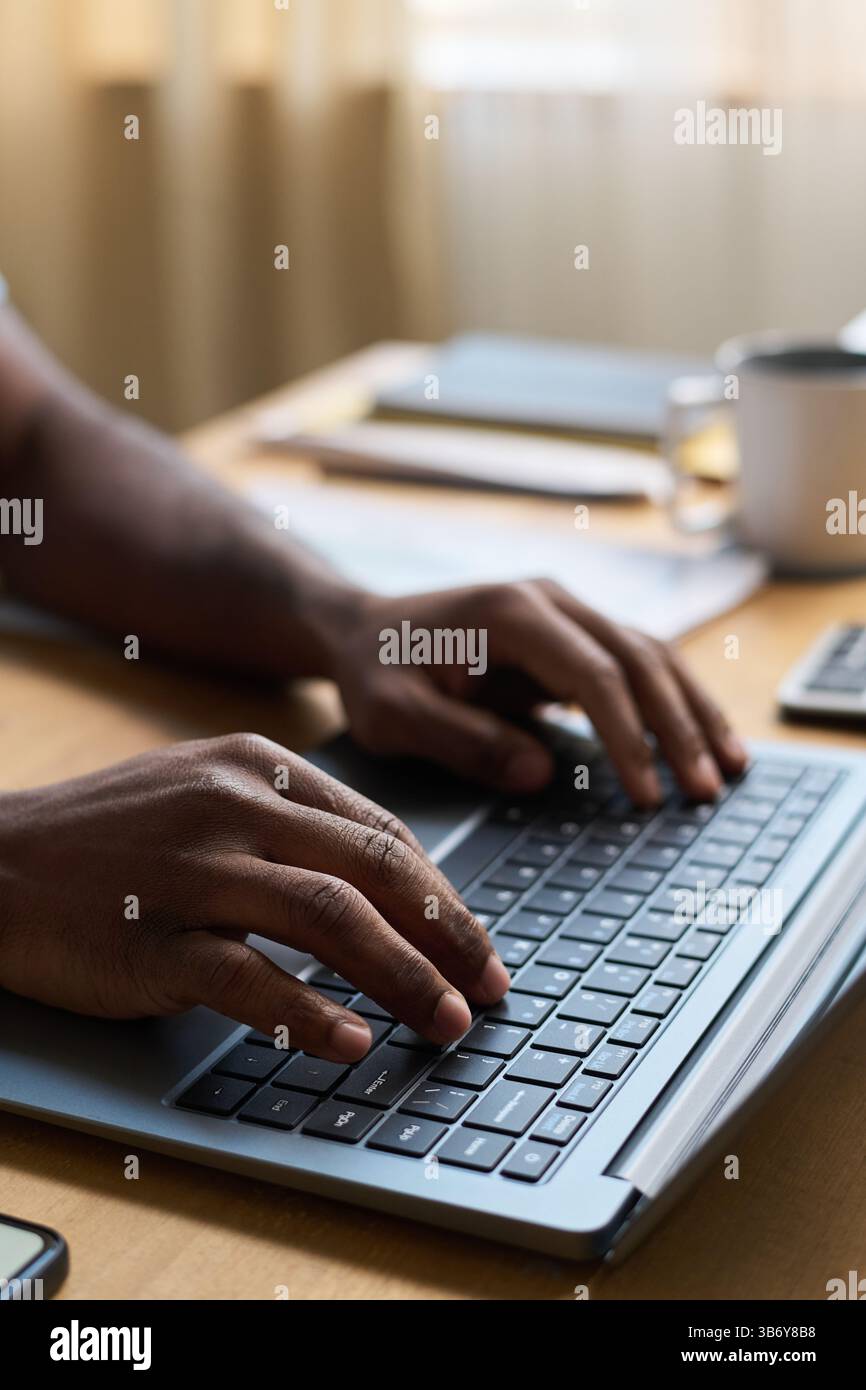 Mains de l'homme méconnaissable tapant sur ordinateur portable au travail Banque D'Images