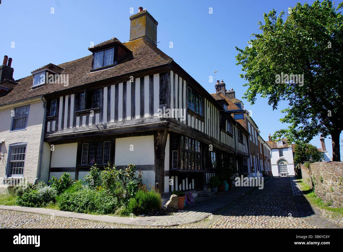 Maison historique à pans de bois sur une rue pavée sous le ciel bleu dans une ville anglaise traditionnelle.Rye, Sussex, Angleterre Banque D'Images