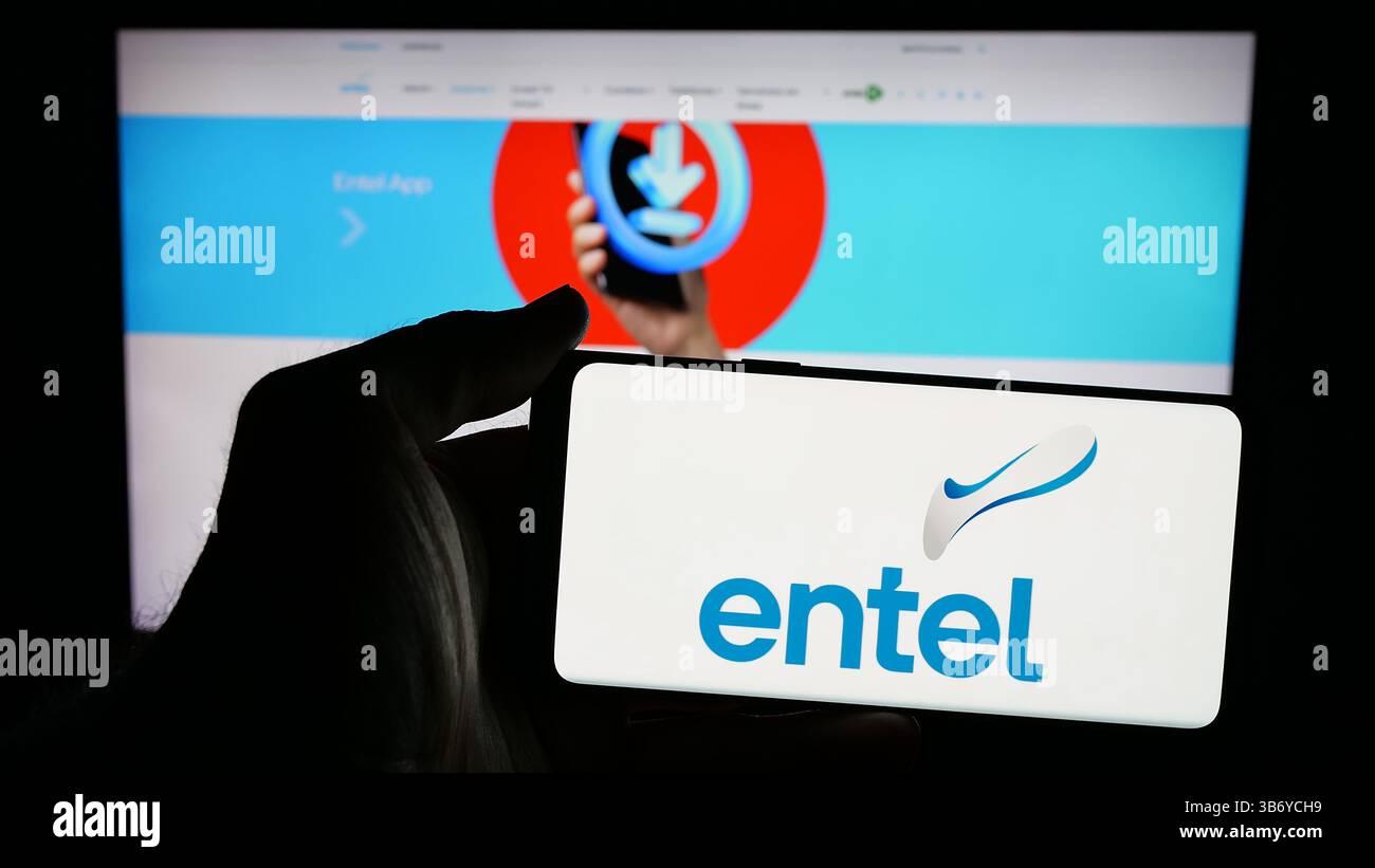 Dans cette illustration photo, une personne tient un téléphone portable avec le logo de la société de télécommunications Entel S.A. sur l'écran devant la page Web. Banque D'Images Dans cette illustration photo, une personne tient un téléphone portable avec le logo de la société de télécommunications Entel S.A. sur l'écran devant la page Web. Banque D'Images