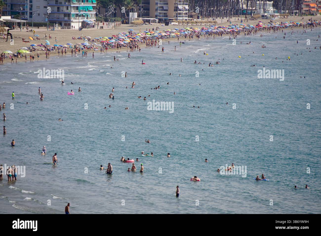 Large vue sur la plage de la Pineda sur la Costa Dorada espagnole avec des nageurs et des parasols colorés le long de la rive méditerranéenne.Salou, Espagne Banque D'Images