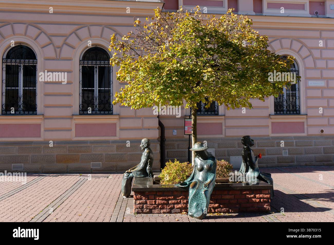 Banc monumental (Ławeczka Poetów) autour de l'arbre avec trois figures, hommage aux grands poètes polonais du XXe siècle. Tarnów, Pologne Banque D'Images