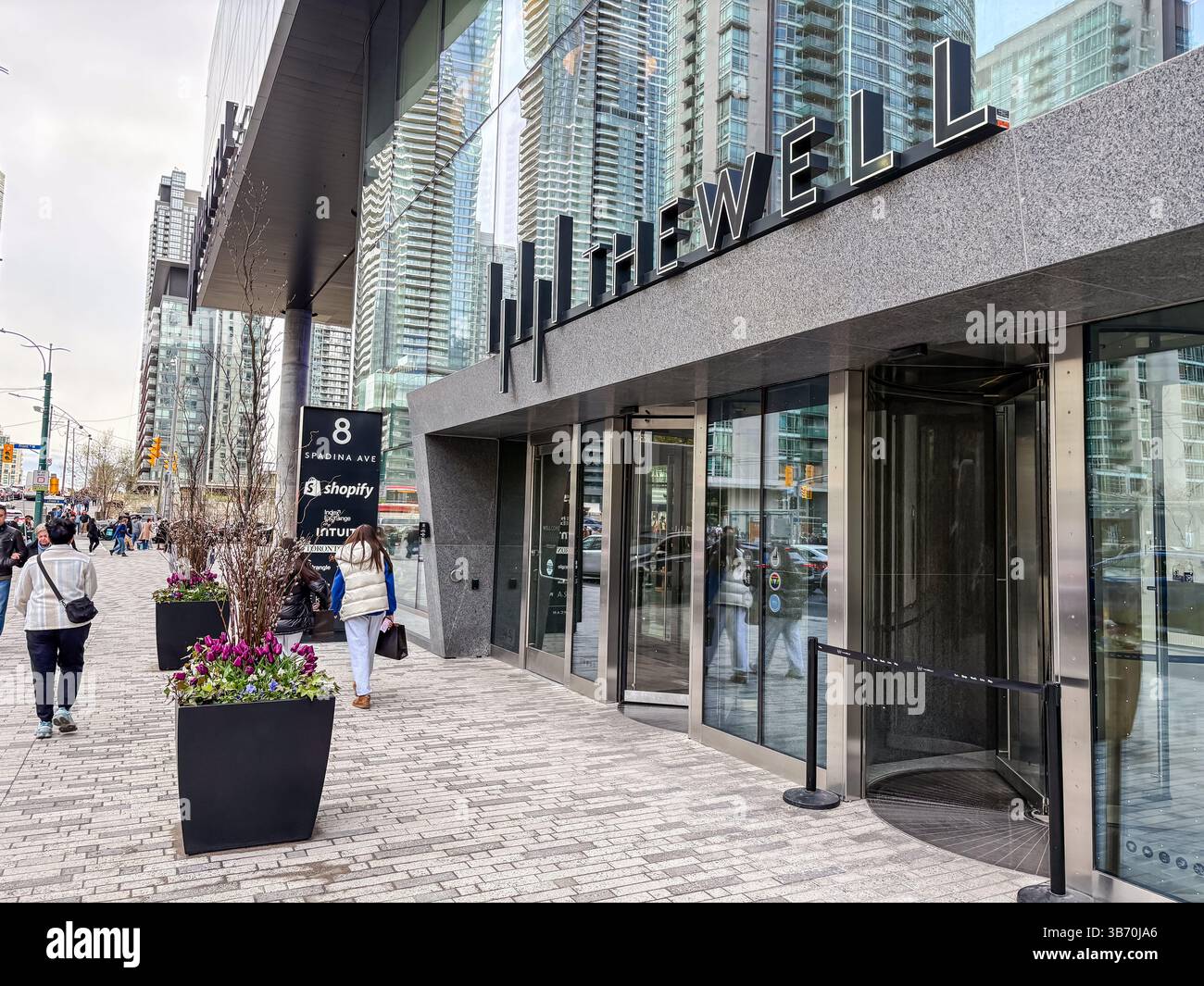 Le puits, Toronto, Canada. Vue extérieure du complexe de bâtiments modernes à usage mixte avec des gens marchant sur le trottoir dans le centre-ville urbain. Banque D'Images