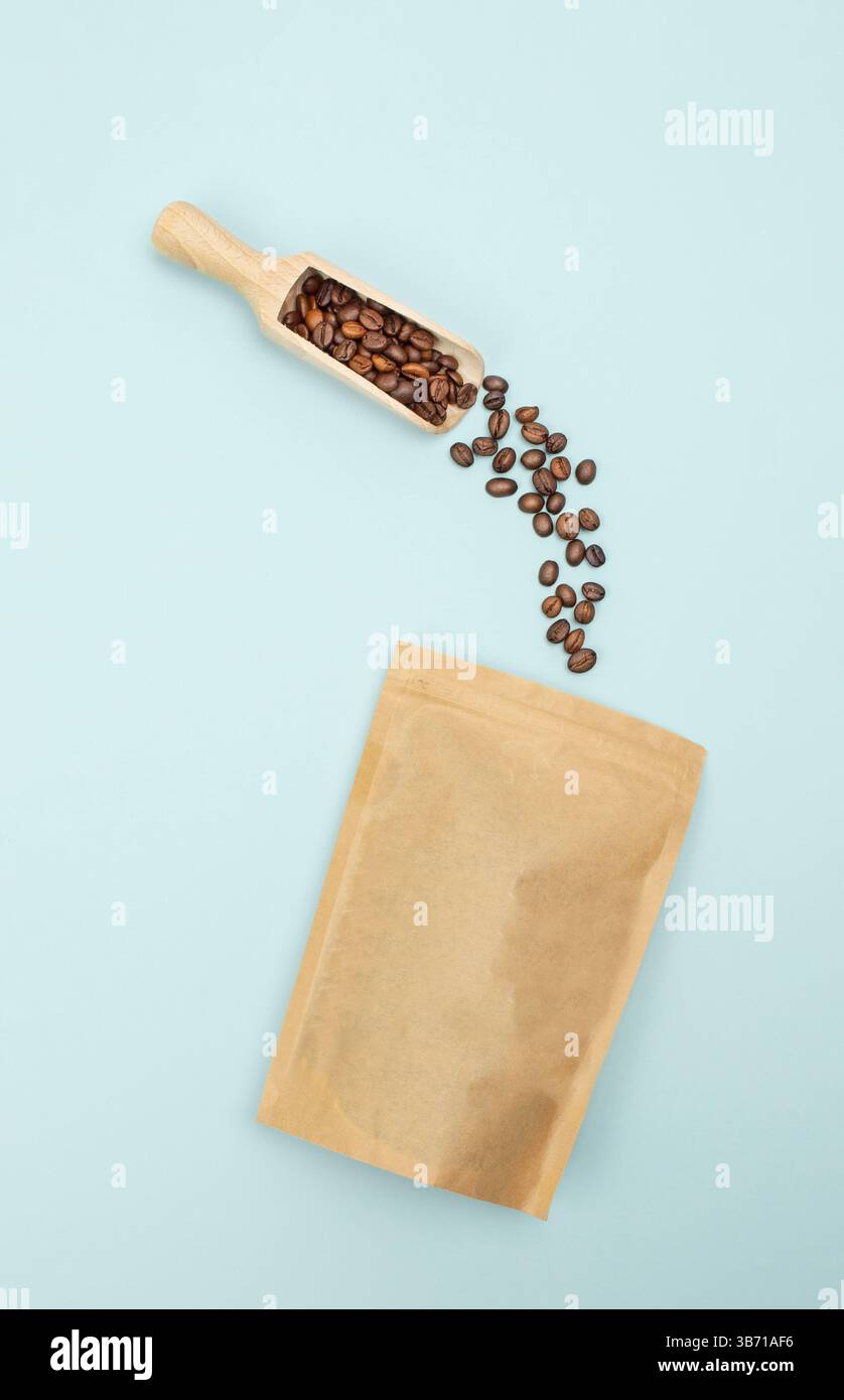 Photo suspendue de haricots versés dans un sac écologique en papier sur bleu, destiné à la marque ou au matériel publicitaire Banque D'Images