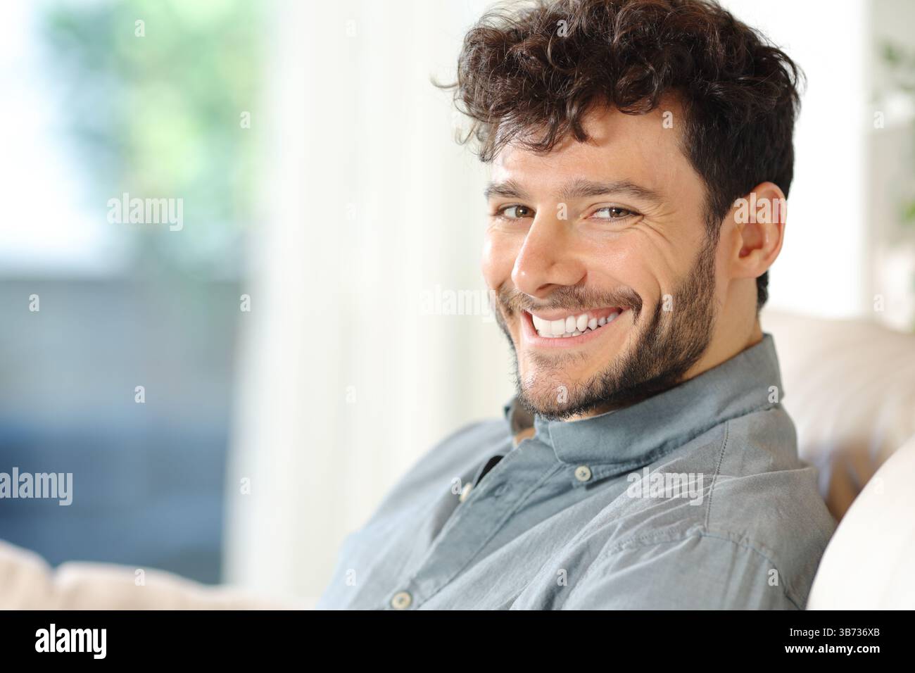 Portrait d'un bel homme heureux souriant à la caméra à la maison Banque D'Images