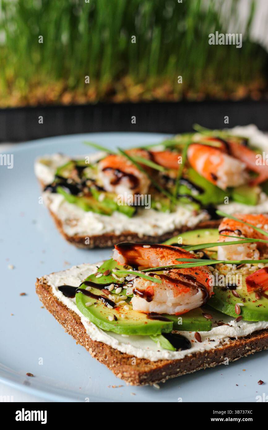 Savoureux toast aux crevettes à l'avocat avec fromage à la crème et glaçage balsamique sur pain de seigle : idée de petit déjeuner sain, alimentation propre, régime cétogène, nourriture scandinave. Banque D'Images