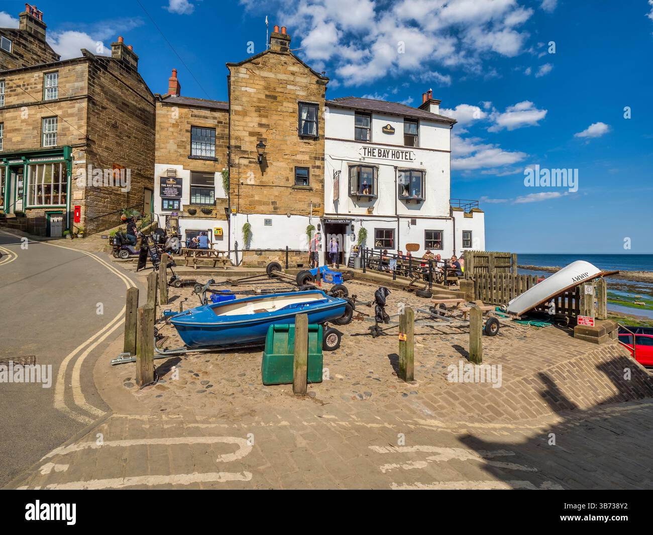Robin Hoods Bay, le Bay Inn, sur une chaude journée d'été, couple entrant par l'entrée. Banque D'Images