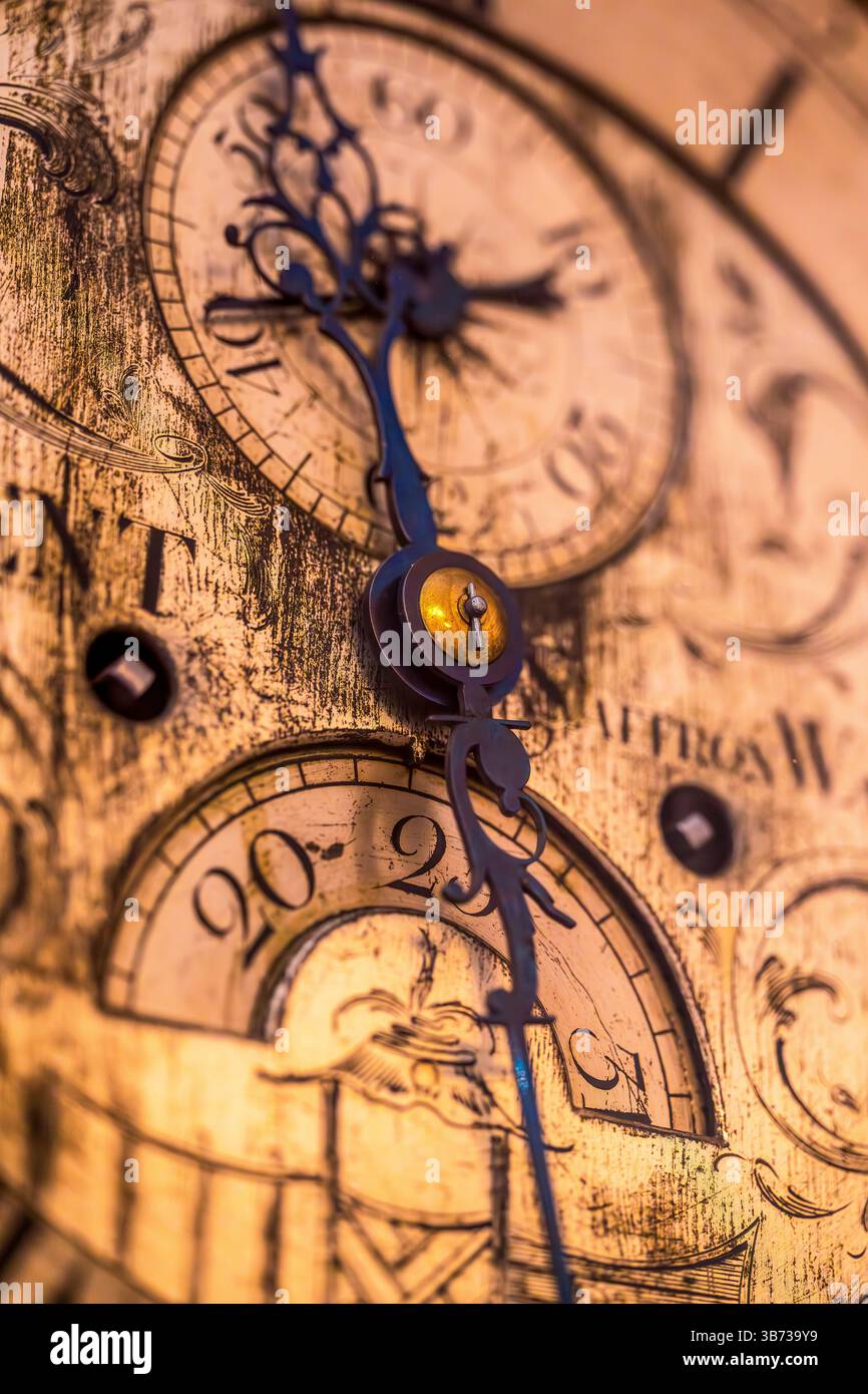 Gros plan d'aiguilles d'horloge ornées et d'un cadran numérique gravé sur une montre antique altérée Banque D'Images