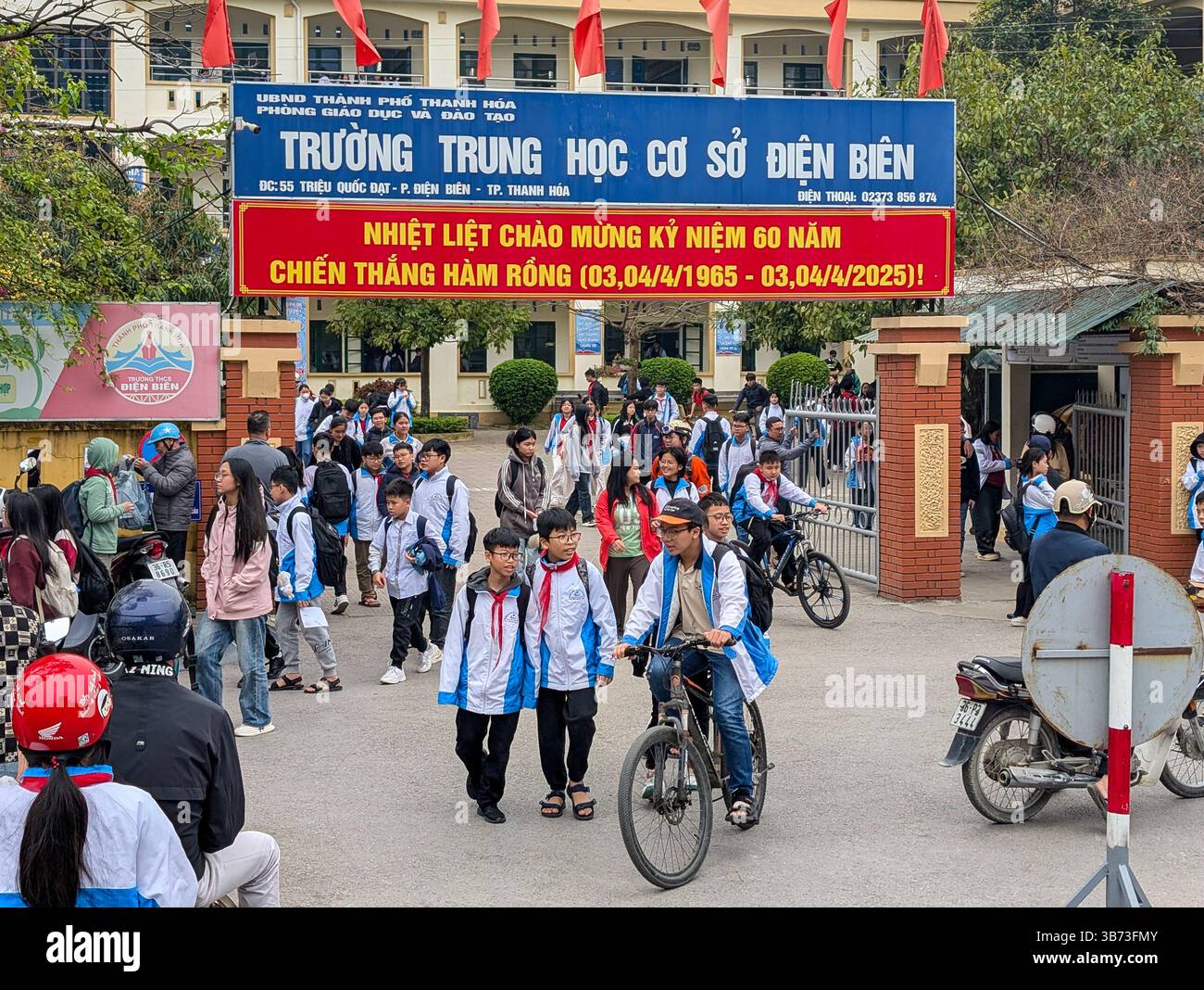 Les élèves d'un collège de Thanh Hoa, au Vietnam, quittent leur école le 18 mars 2025 après les cours. Les élèves sont vêtus d'uniformes blancs et bleus. Banque D'Images