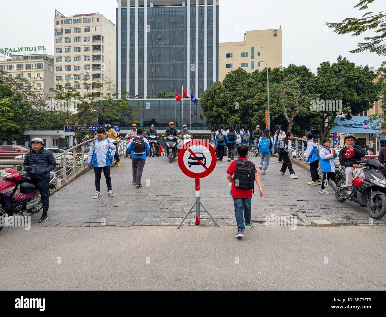 Les élèves d'un collège de Thanh Hoa, au Vietnam, quittent leur école le 18 mars 2025 après les cours. Les élèves sont vêtus d'uniformes blancs et bleus. Banque D'Images