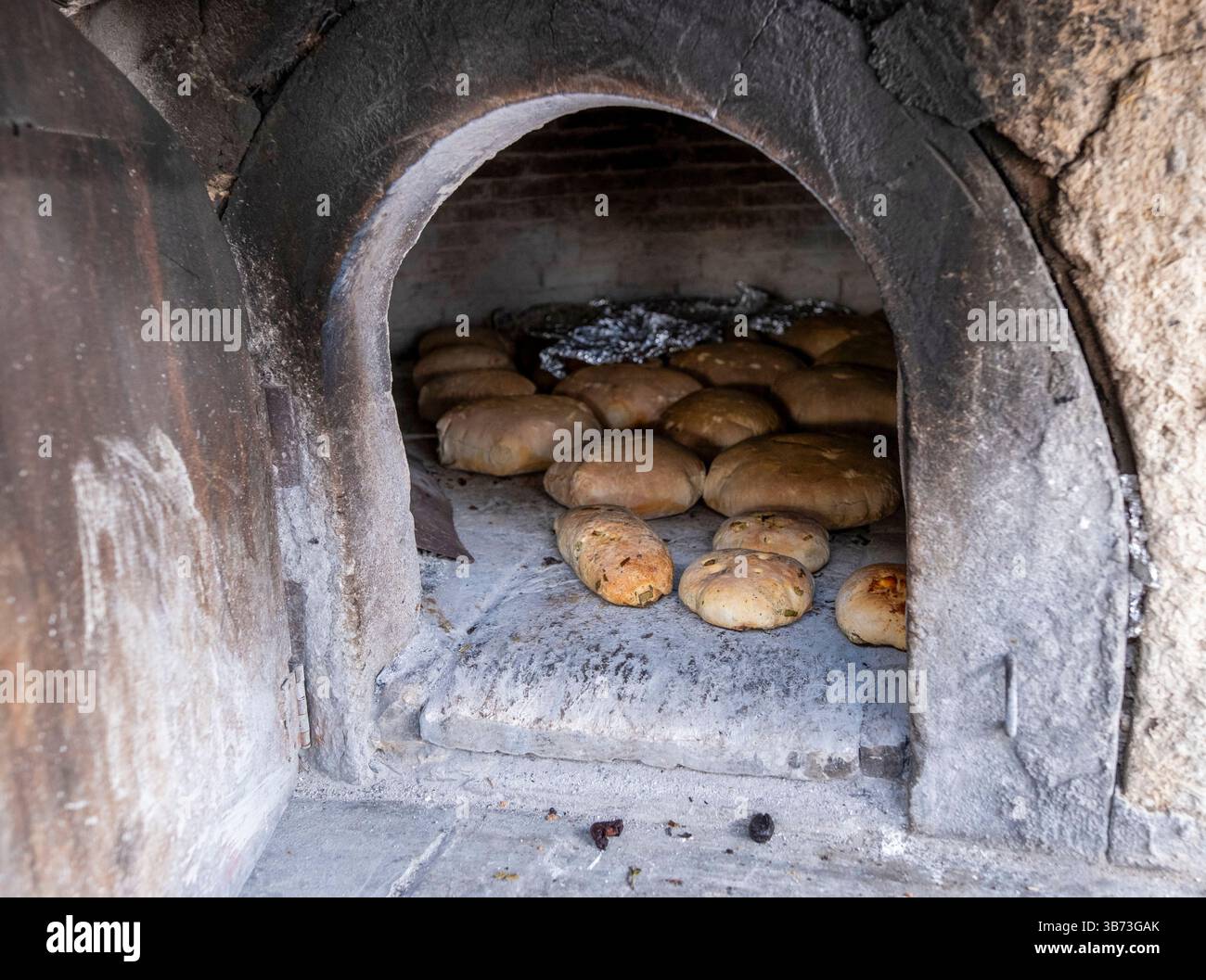 Femme âgée faisant du pain dans un four à pain traditionnel, Korucam (Kormakiti) village maronite - Chypre du Nord. Banque D'Images