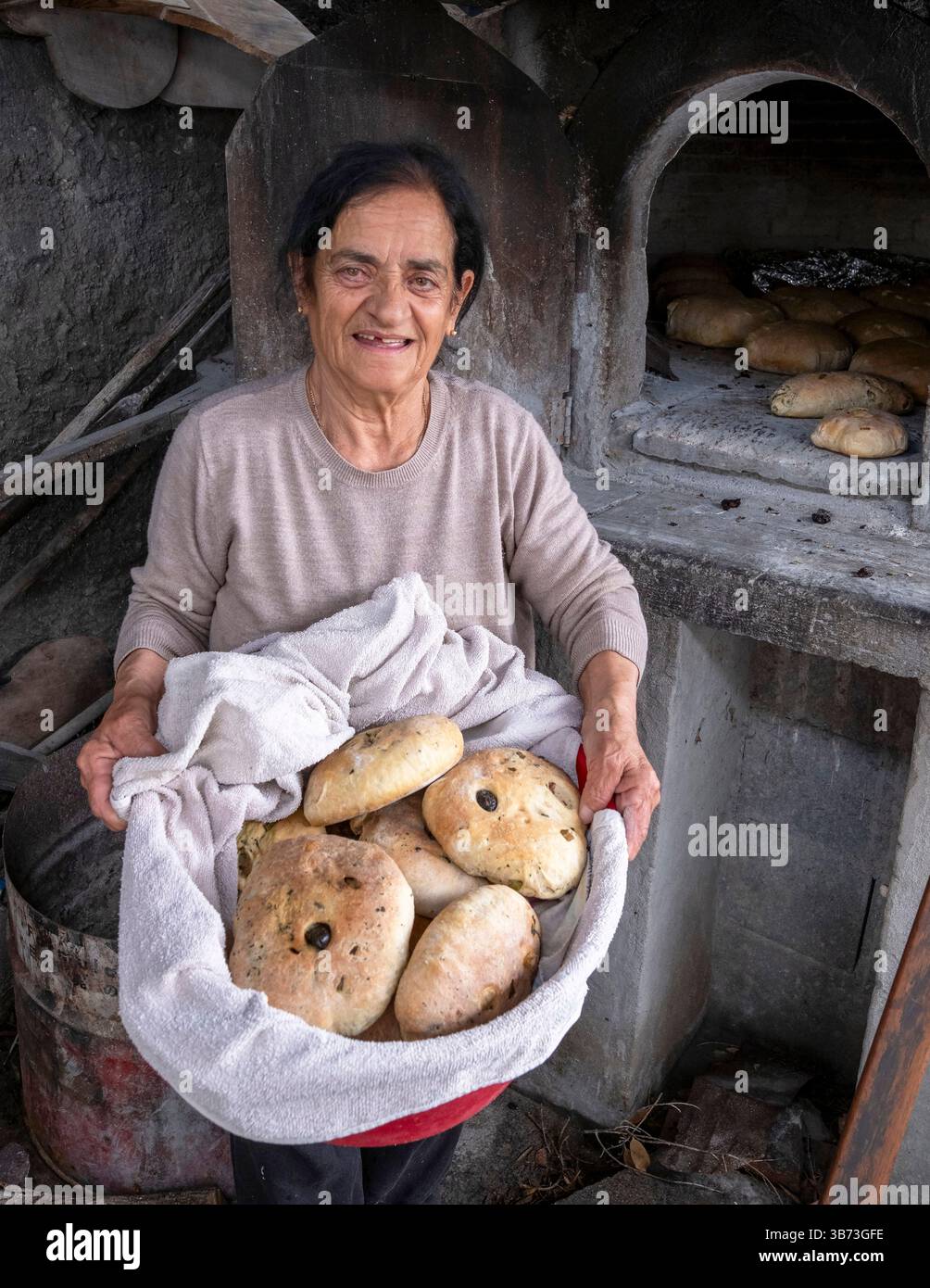 Femme âgée faisant du pain dans un four à pain traditionnel, Korucam (Kormakiti) village maronite - Chypre du Nord. Banque D'Images