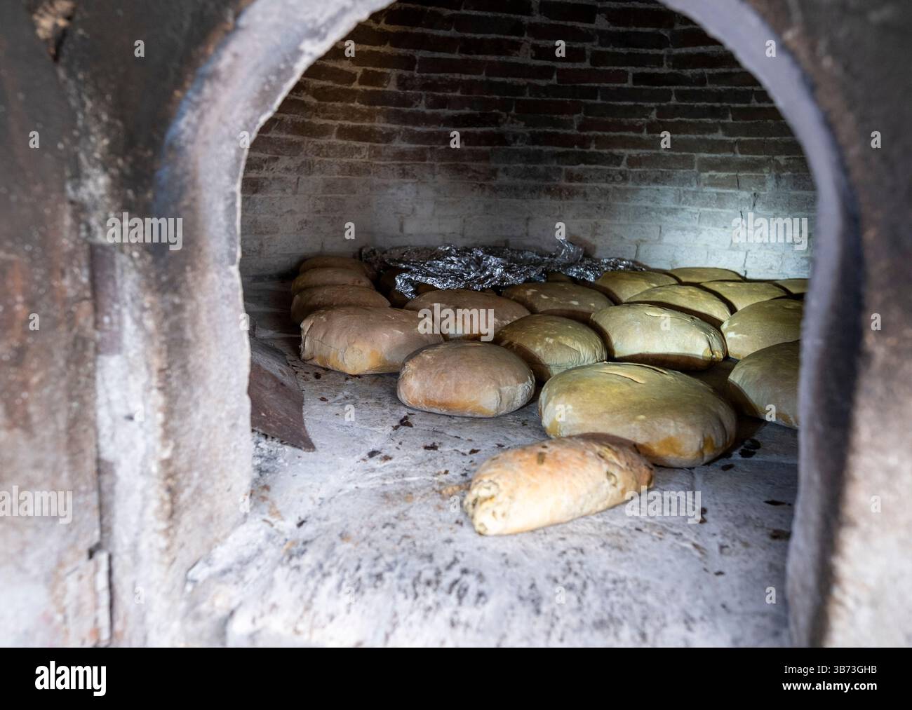 Femme âgée faisant du pain dans un four à pain traditionnel, Korucam (Kormakiti) village maronite - Chypre du Nord. Banque D'Images