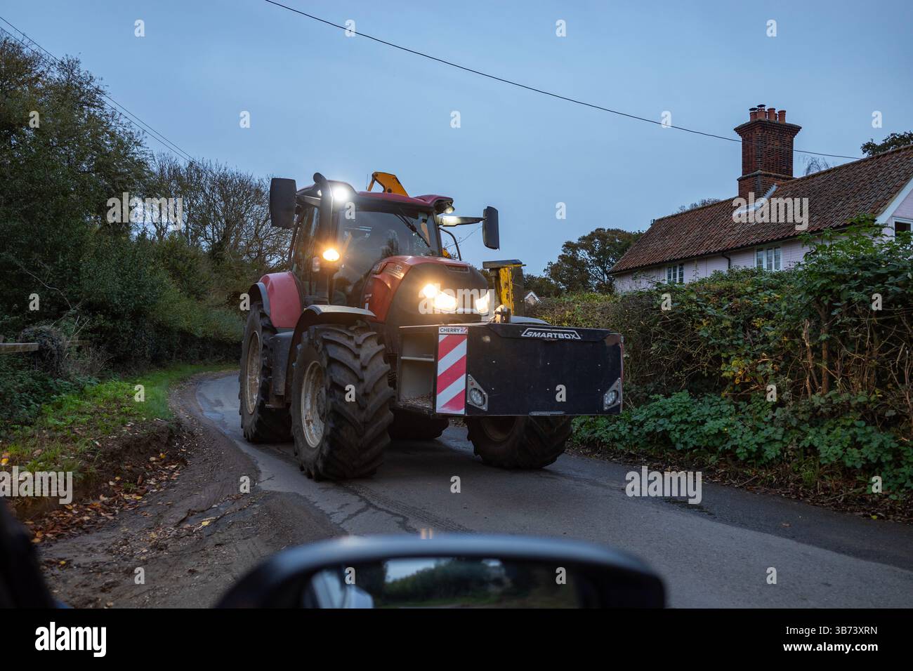 Tracteur sur la route de campagne étroite Bawdsey Suffolk UK Banque D'Images