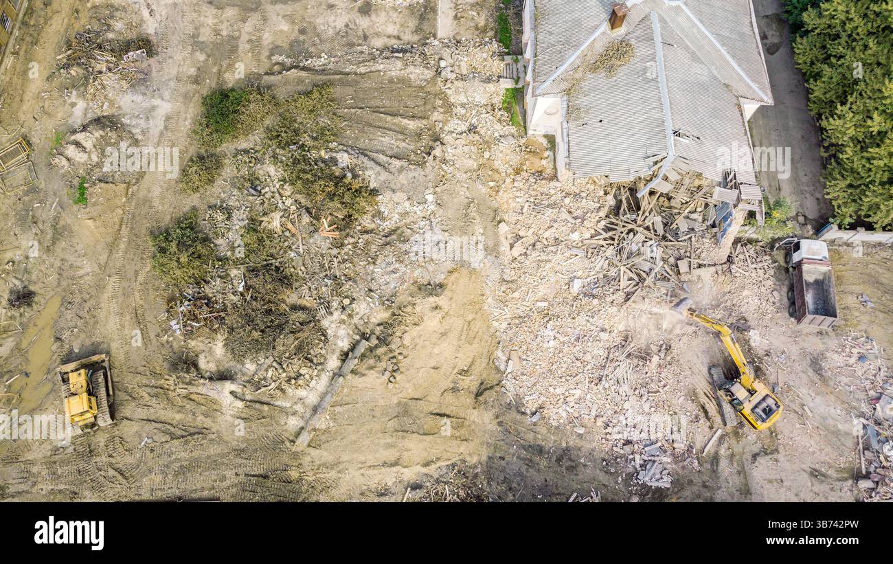 chantier de démolition avec des machines lourdes en fonctionnement et tas de débris de bâtiment détruit. vue aérienne par drone. Banque D'Images