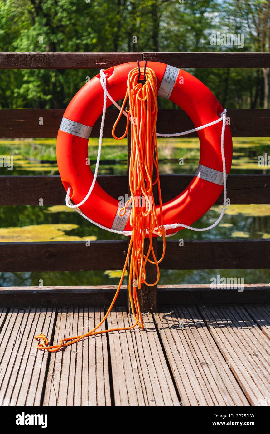 Ceinture de sauvetage rouge suspendue à une plate-forme en bois sur le lac Banque D'Images