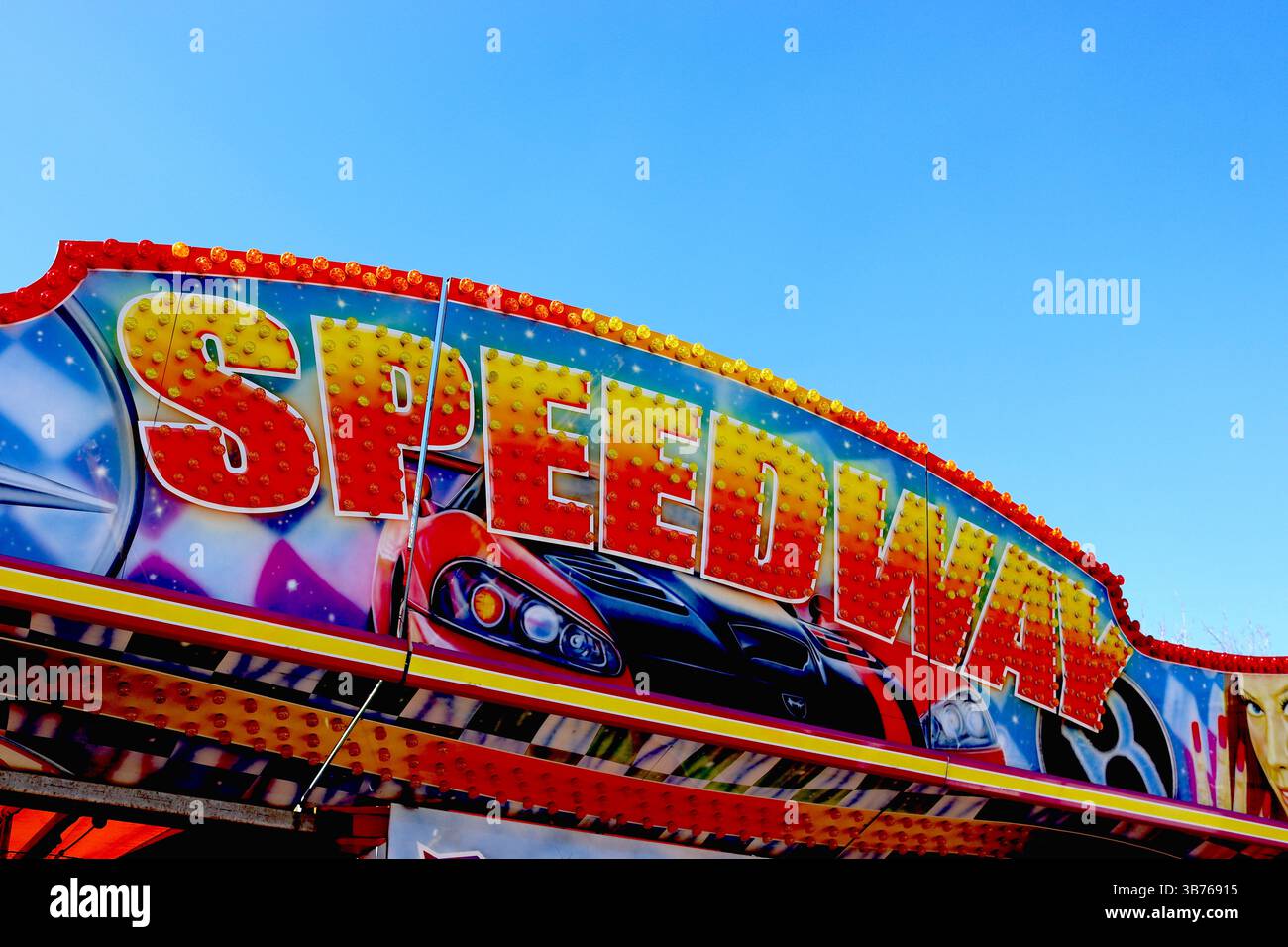 Signalisation colorée combinant l'art aérographe, des couleurs vives et des centaines d'ampoules LED sur un panneau d'en-tête de dodgem Ride itinérant Fairground Speedway. Banque D'Images