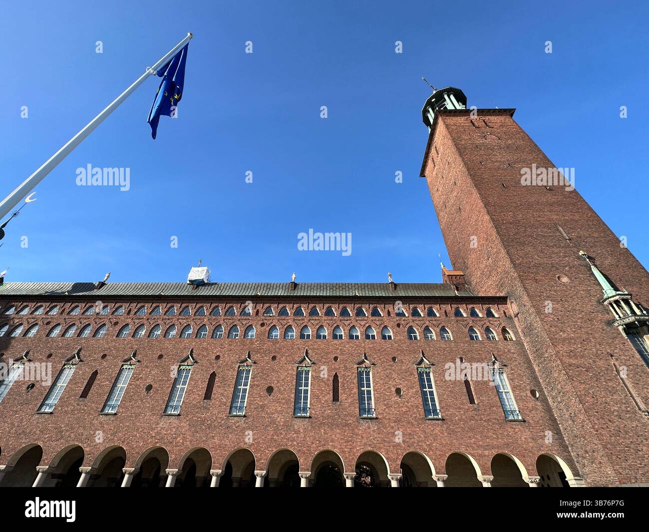 L'emblématique Hôtel de ville de Stockholm avec ses briques saisissantes et un ciel bleu clair. - Image de stock capturée avec un smartphone