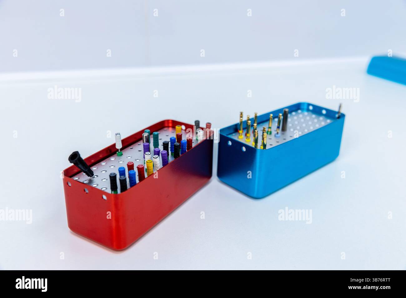 Cette image présente deux conteneurs soigneusement organisés, un rouge et un bleu, remplis d'une variété d'outils et de composants précis parfaits pour les artisans Banque D'Images