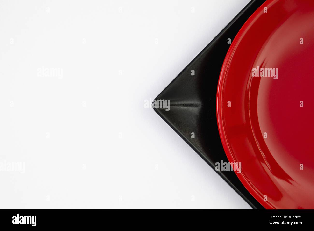 Différentes plaques rouges et noires sur la table blanche.vue de dessus. Image à plat Banque D'Images