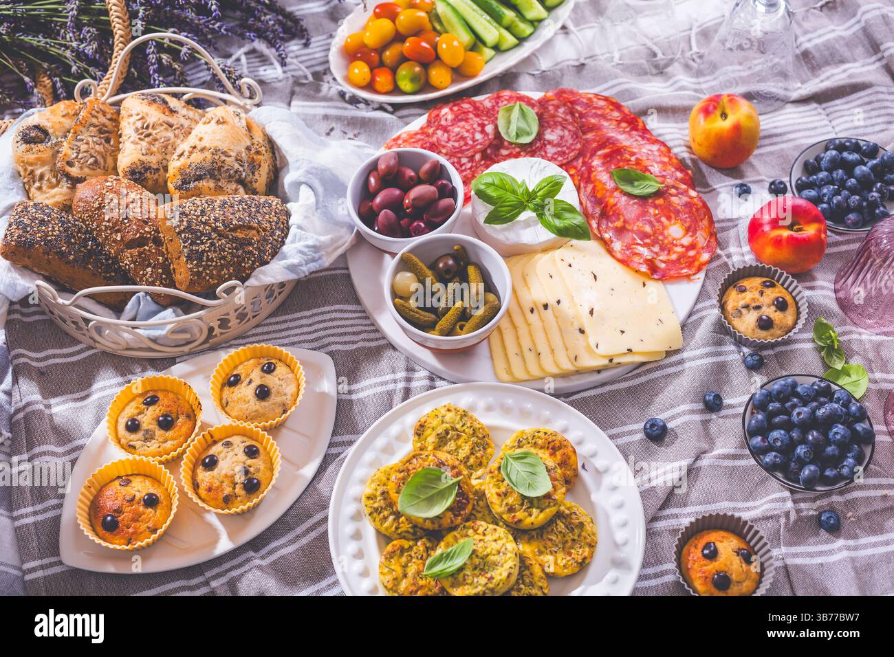 Pique-nique, hors-d'œuvre et plateau de fromage et de viande avec muffins sucrés et salés et fruits Banque D'Images