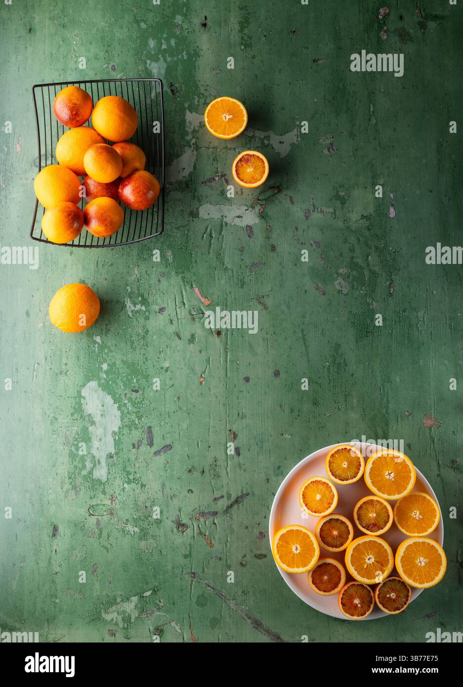 Oranges tranchées et entières avec des citrons sur un fond vert texturé Banque D'Images