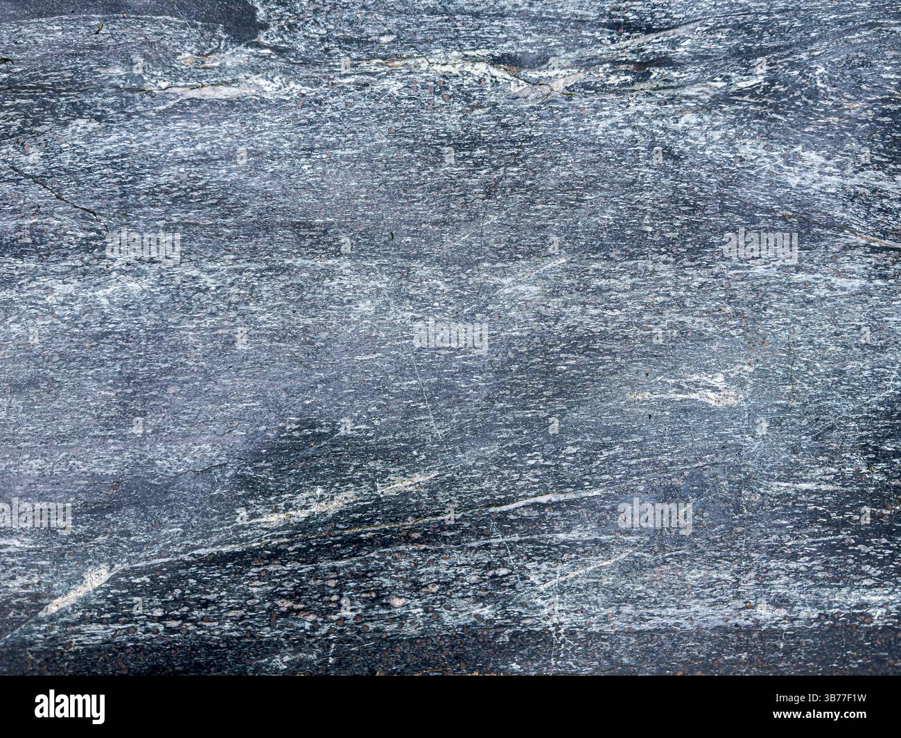 Surface en pierre texturée bleu-gris avec motifs minéraux naturels et détails rugueux. Banque D'Images