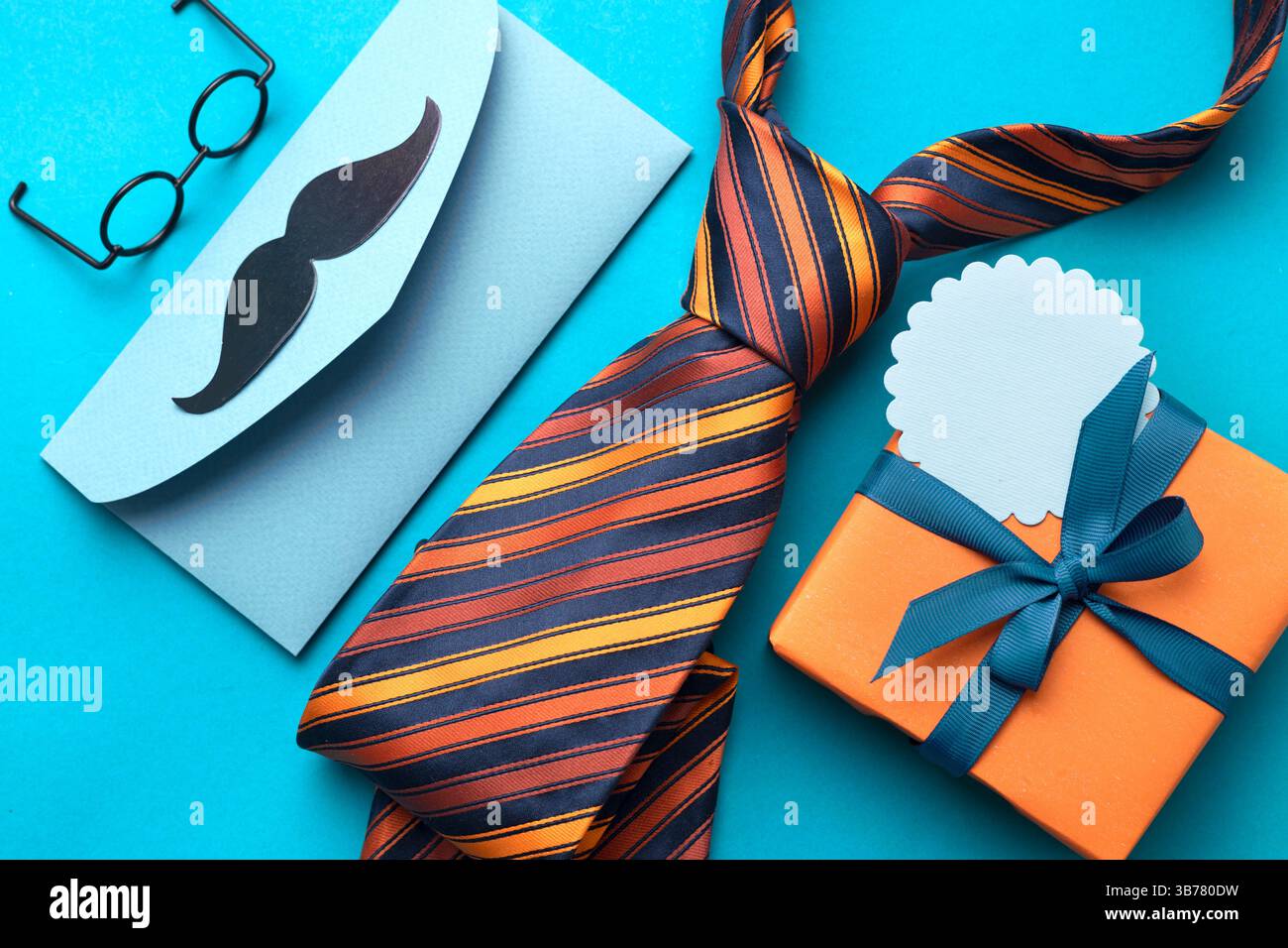 Vue de dessus des objets masculins flatlay de fête des pères sur fond bleu.Tie boîte cadeau orange et message.affiche de fête des pères, carte vide espace de copie tag.Greeting c Banque D'Images