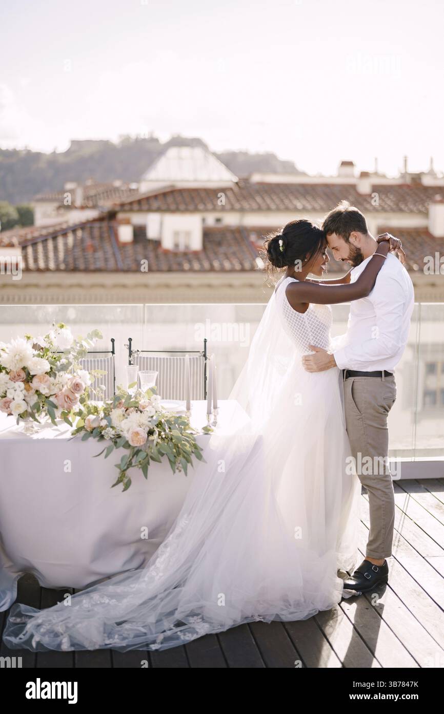 Couple de mariage interracial. Destination mariage beaux-arts à Florence, Italie. Mariée afro-américaine et mariée caucasienne se tiennent près de la table pour une mariée Banque D'Images