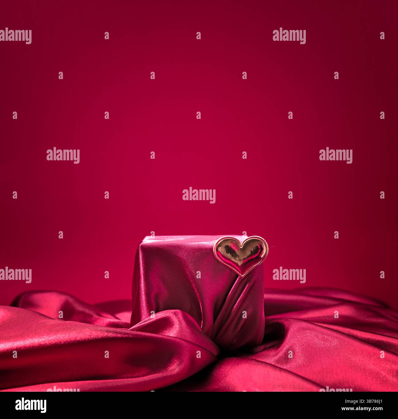 Scène de satin carré rouge décorée avec coeur, fond de Saint-Valentin, étape de promotion de produit, podium de soie, affichage élégant, placement de luxe, ped rose Banque D'Images