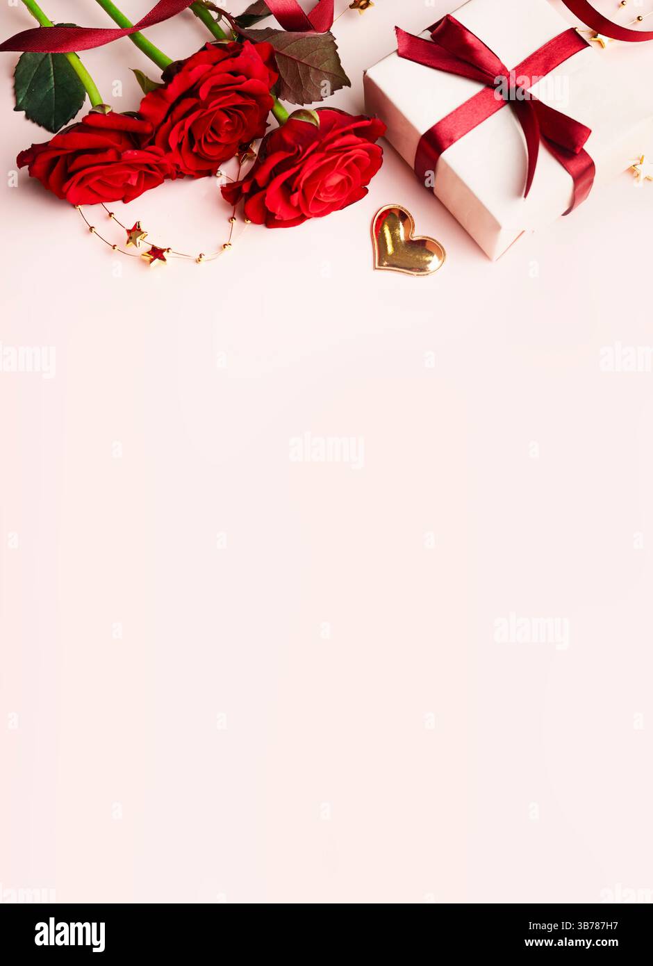 Bouquet de roses rouges décoré avec hert et boîte-cadeau vue de dessus sur fond rose.concept de datation.carte verticale de Saint-Valentin. Fleurs bordent la pose à plat. W Banque D'Images