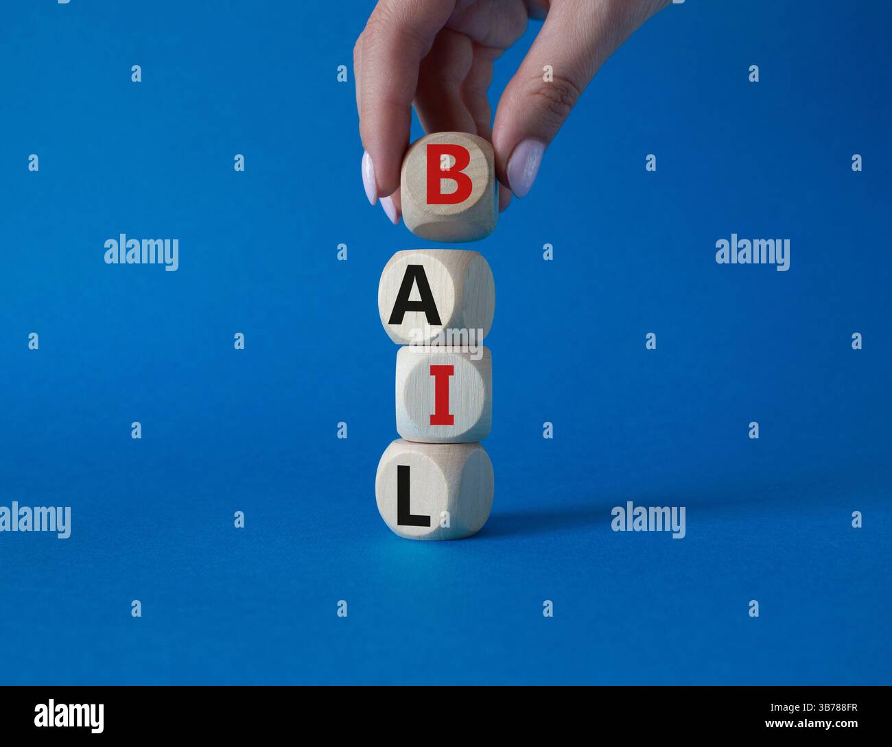 Symbole de béquille. Concept mot bail sur cubes en bois. Main d'homme d'affaires. Beau fond bleu. Business and bail concept. Copier l'espace. Banque D'Images