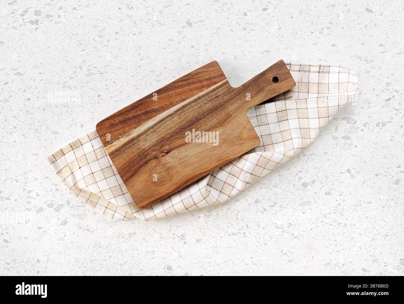 Planche à découper vue de dessus, plateau en bois de cuisine décoré avec un tissu plié à carreaux sur une table blanche.toile de fond de nourriture. Videz la vaisselle. Banque D'Images