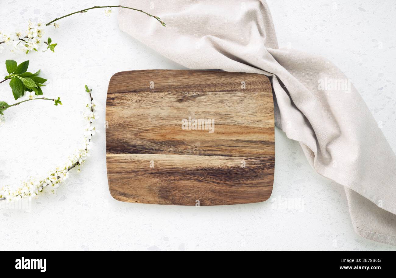 Planche à découper vue de dessus, plateau en bois de cuisine décoré avec du tissu et de la plante sur la table blanche.toile de fond de nourriture. Videz la vaisselle. Banque D'Images