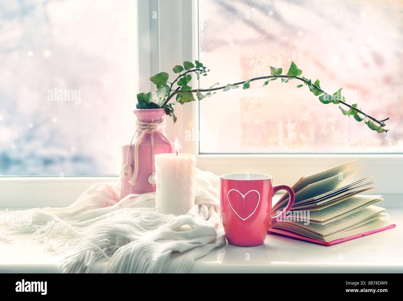 Carte de Saint-Valentin. Tasse rouge en forme de coeur sur le rebord de la fenêtre fond vide d'espace de copie. Concept de stile de vie confortable d'hiver. Banque D'Images