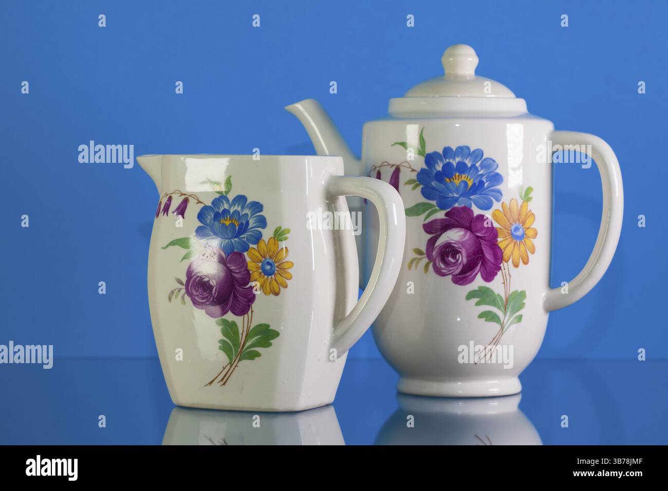 Ensemble de thé en porcelaine très ancien sur fond de réflexion bleu Banque D'Images