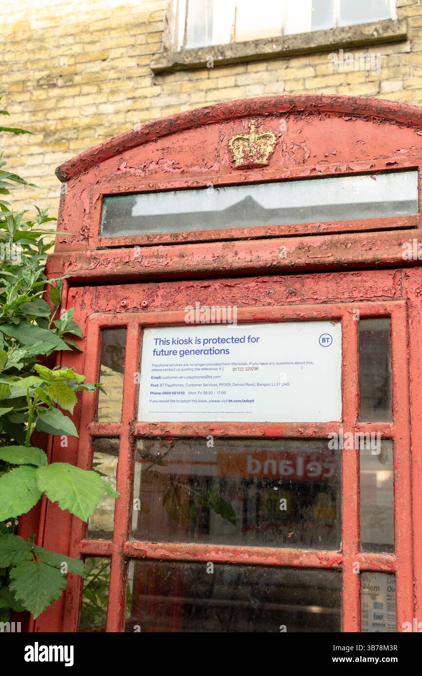 Vieux kiosque téléphonique rouge désaffecté avec peinture pelable protégé pour les générations futures Banque D'Images