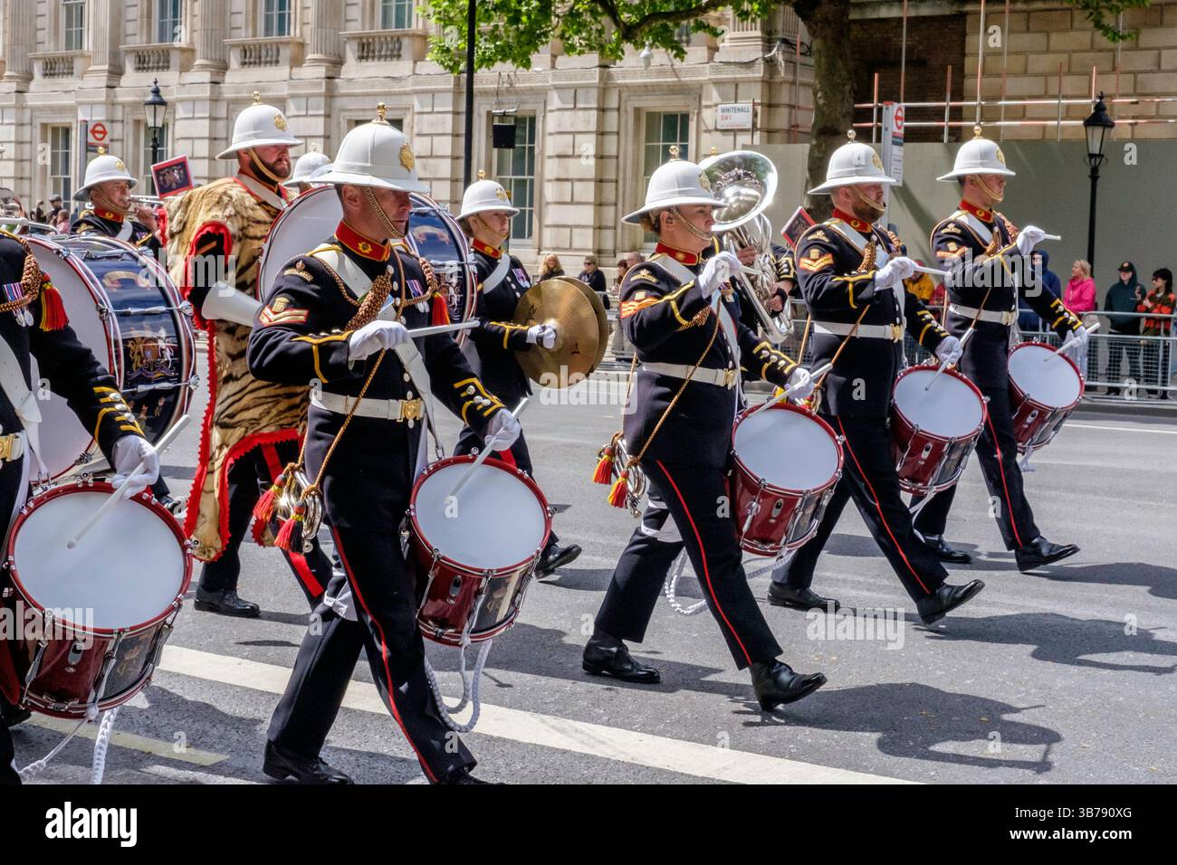 5 mai 2025, Londres, Royaume-Uni. Commémoration de la Journée VE. Un défilé de militaires britanniques et internationaux a lieu dans le centre de Londres pour marquer le 80e anniversaire de la fin de la seconde Guerre mondiale en Europe. Sur la photo : les groupes des Royal Marines de sa Majesté se produisent le long de la route lors de la procession commémorative du VE Day dans le centre de Londres. Banque D'Images