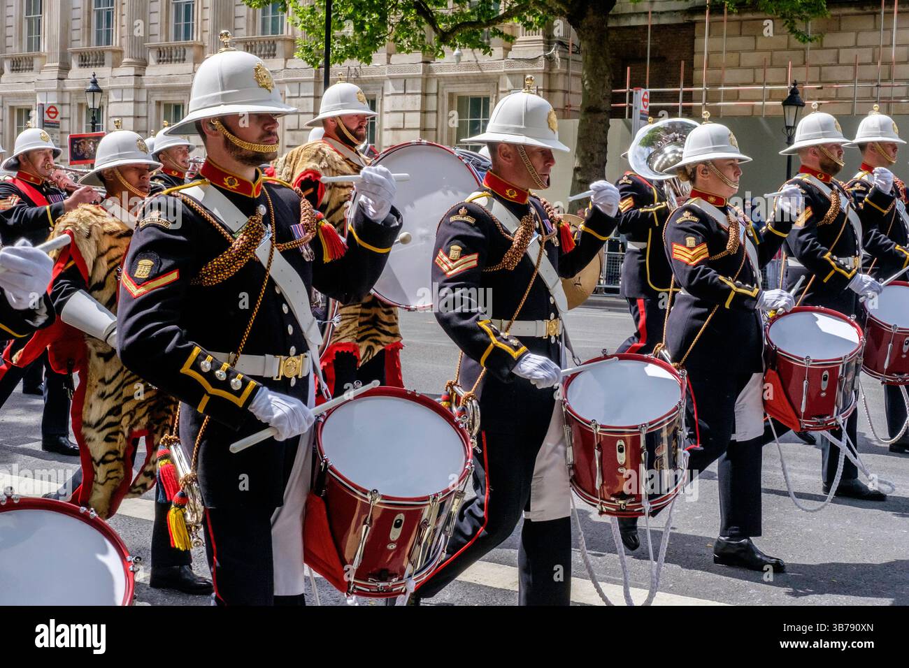 5 mai 2025, Londres, Royaume-Uni. Commémoration de la Journée VE. Un défilé de militaires britanniques et internationaux a lieu dans le centre de Londres pour marquer le 80e anniversaire de la fin de la seconde Guerre mondiale en Europe. Sur la photo : les Royal Marines de la bande de sa Majesté jouent le long de la route lors de la procession commémorative du VE Day dans le centre de Londres. Banque D'Images