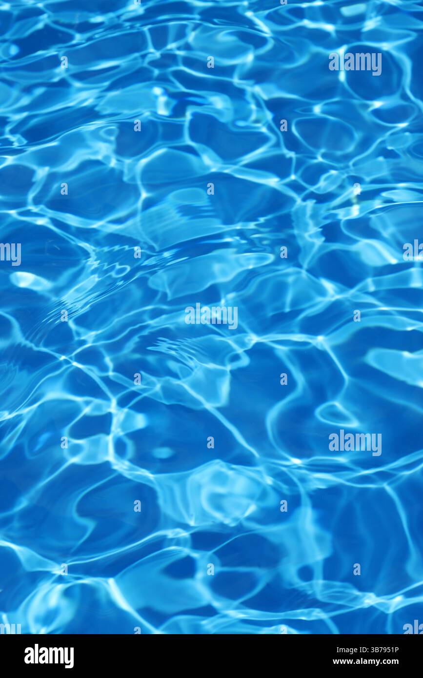 Ondulations légères reflétant dans le fond d'eau bleu de la piscine Banque D'Images