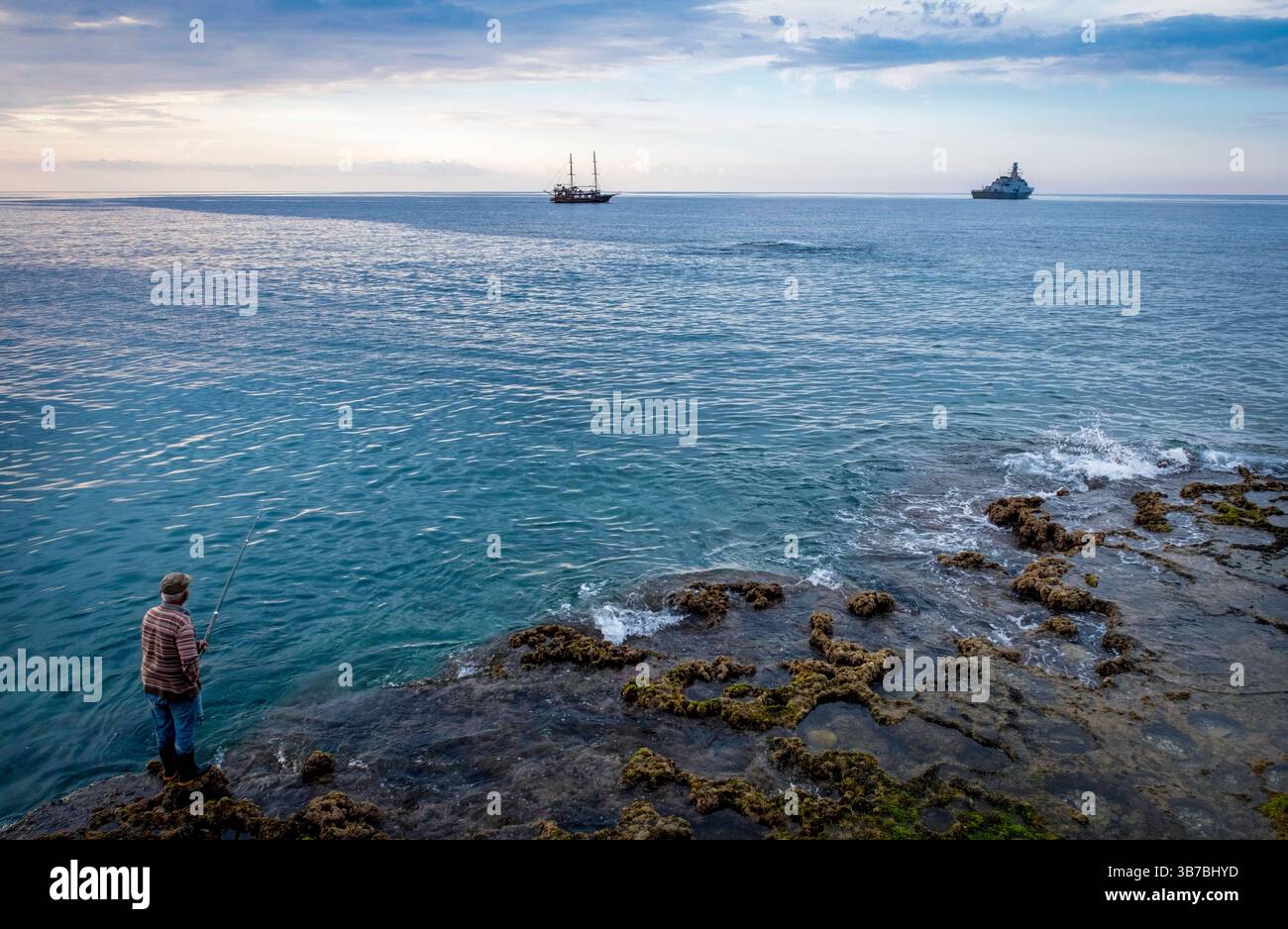 Un homme pêchant dans le port de Kyrenia, Kyrenia, Chypre du Nord. Banque D'Images