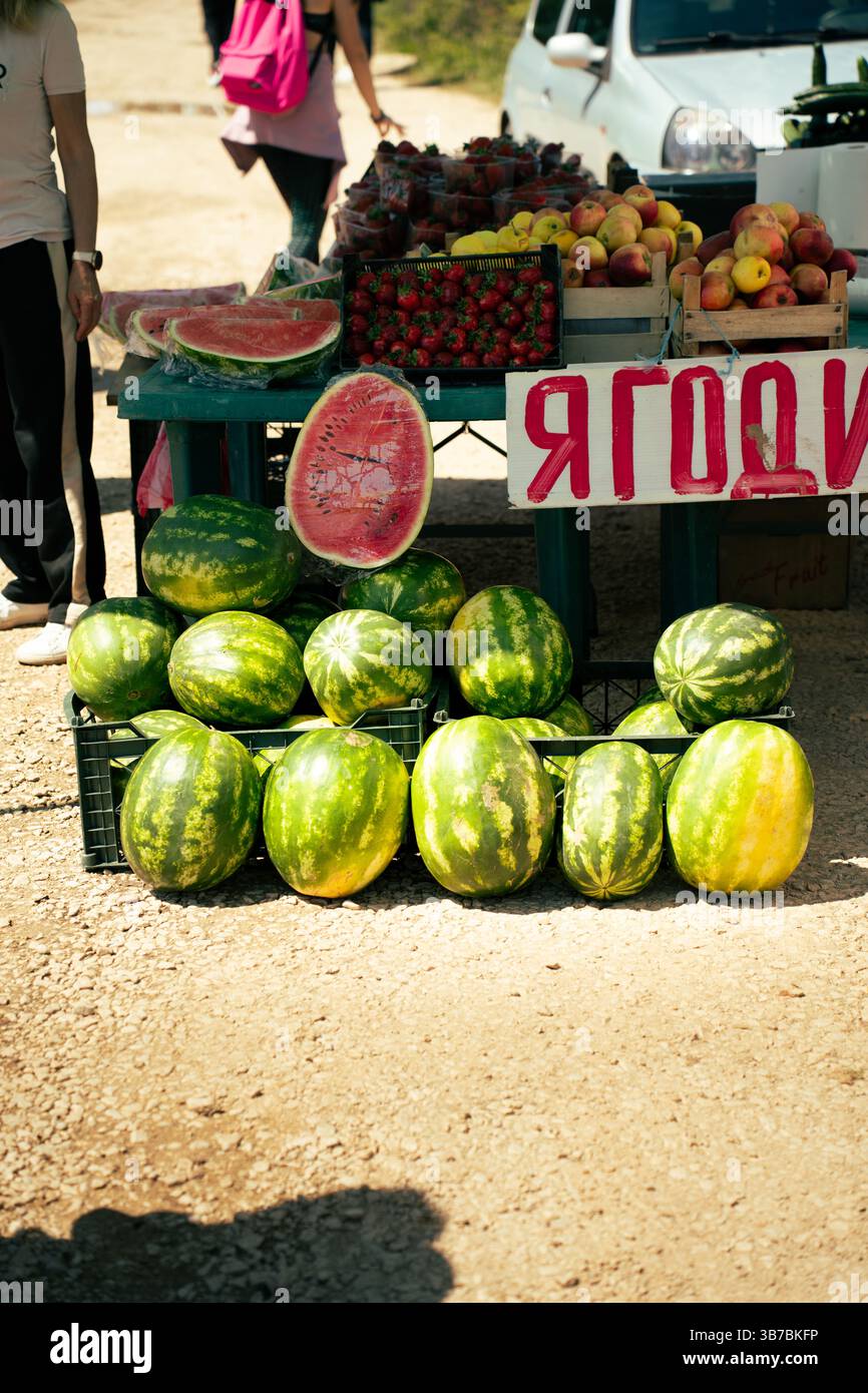 Stand de fruits extérieur vendre des pastèques, des fraises et des pommes dans un marché rural en Bulgarie Banque D'Images