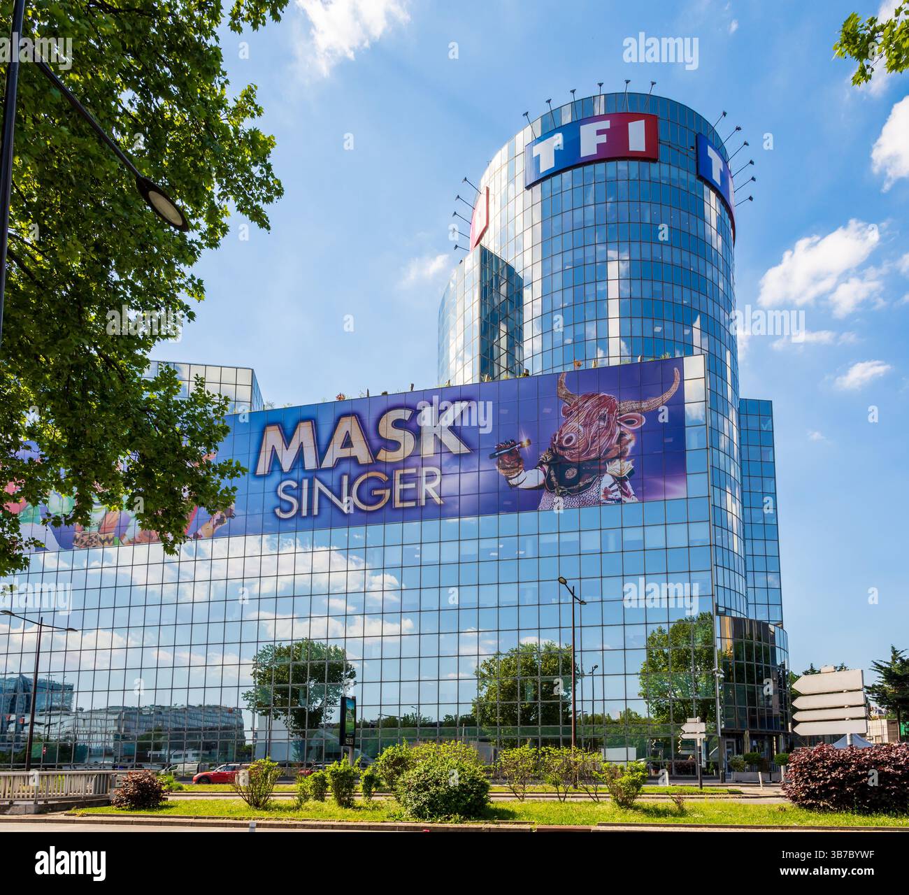 La tour TF1 à Boulogne-Billancourt, siège de la chaîne de télévision française TF1, affichant une énorme bannière pour l'émission Mask Singer. Banque D'Images