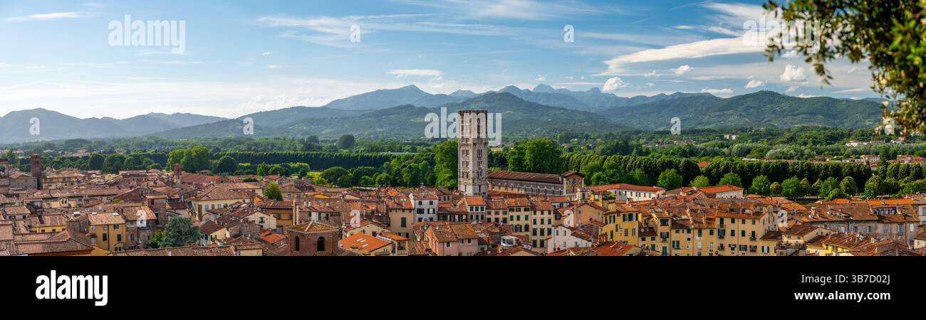 Vue panoramique de Lucques, Italie, avec des toits en briques rouges et des églises historiques vues d'en haut. Les collines et les montagnes toscanes forment un magnifique arrière-plan estival Banque D'Images
