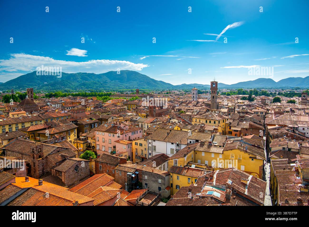 Vue panoramique de Lucques, Italie, avec des toits en briques rouges et des églises historiques vues d'en haut. Les collines et les montagnes toscanes forment un magnifique arrière-plan estival Banque D'Images